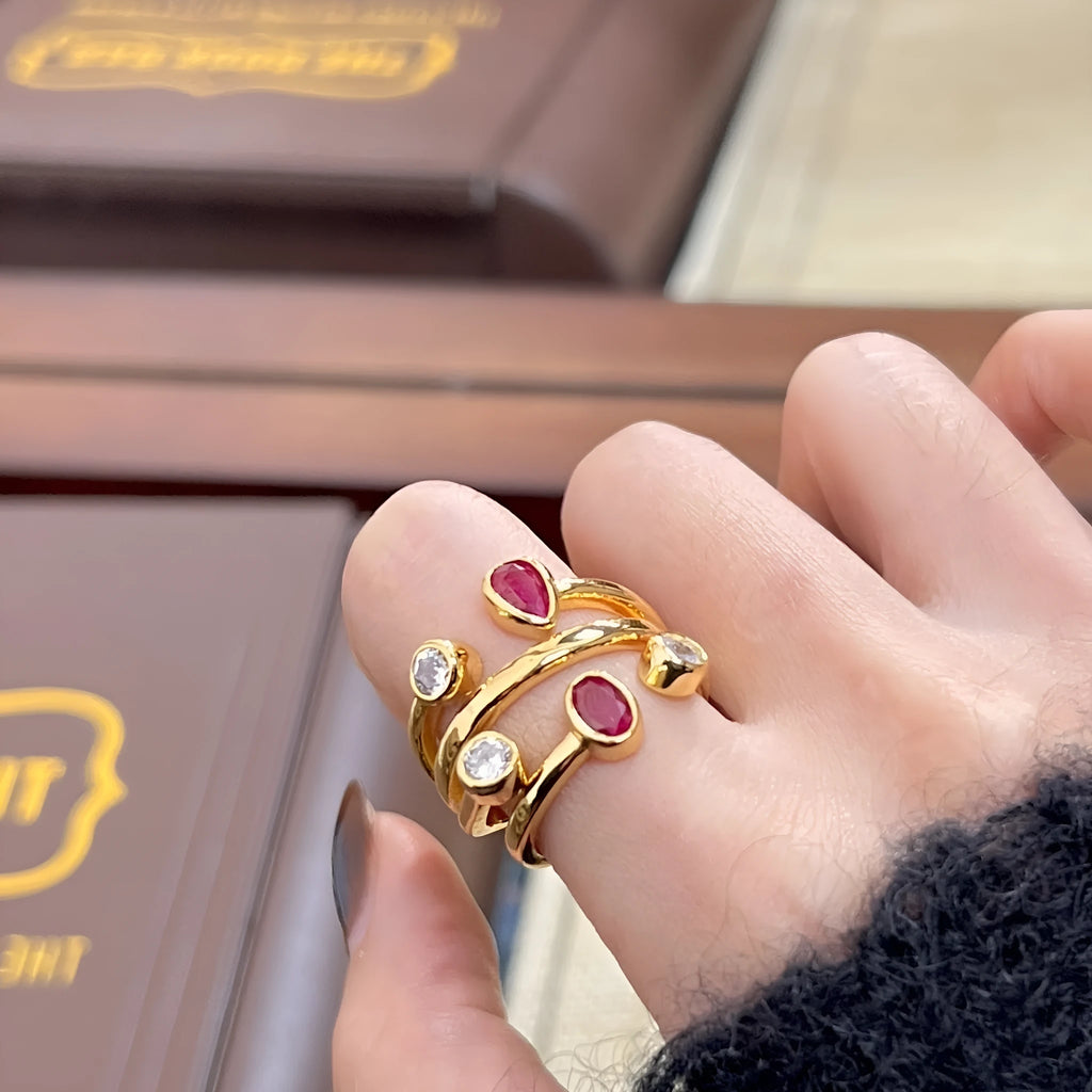 Geometric copper ring with irregular cross design in two-tone red and white colours.