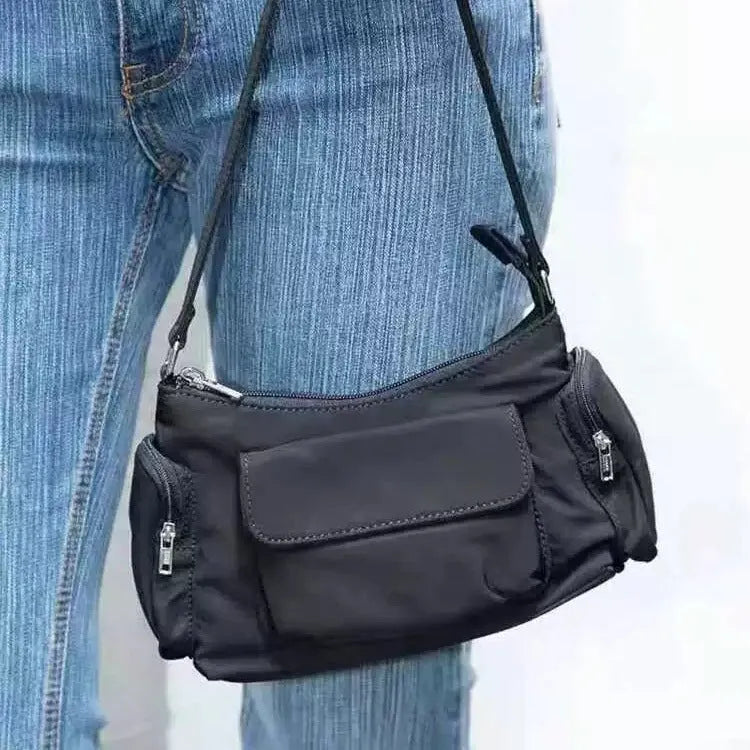 Black women's shoulder bag with double pockets and crossbody strap showing side line detailing