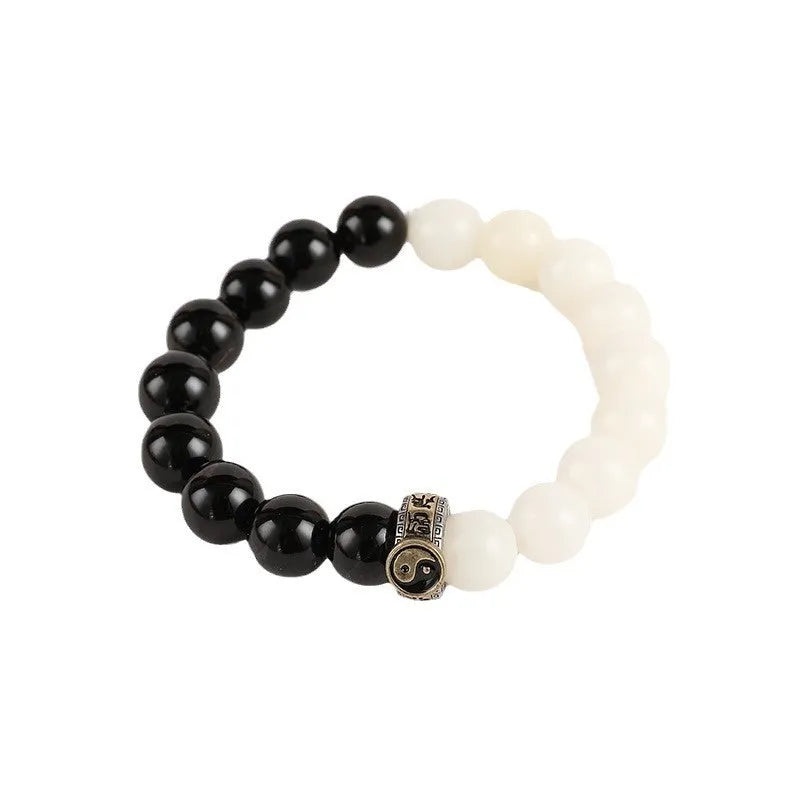 Black and white obsidian geometry-shaped bead bracelet on neutral background