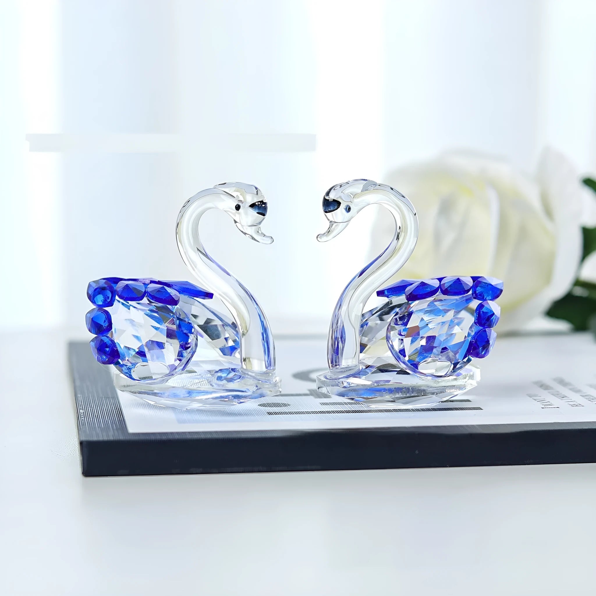 White crystal swan ornament in red, blue, pink, or purple on wooden desk
