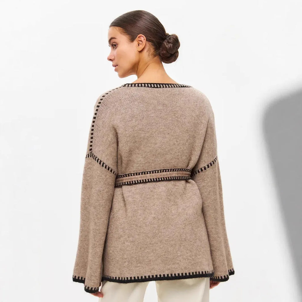 Loose knit camel coloured cardigan sweater with long sleeves on a hanger