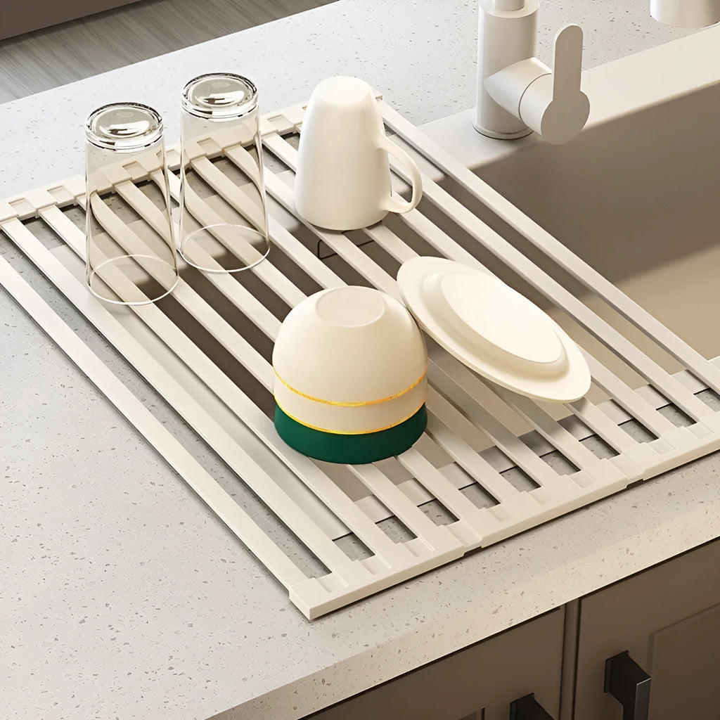 Milky white foldable stainless steel kitchen draining rack placed next to a sink.