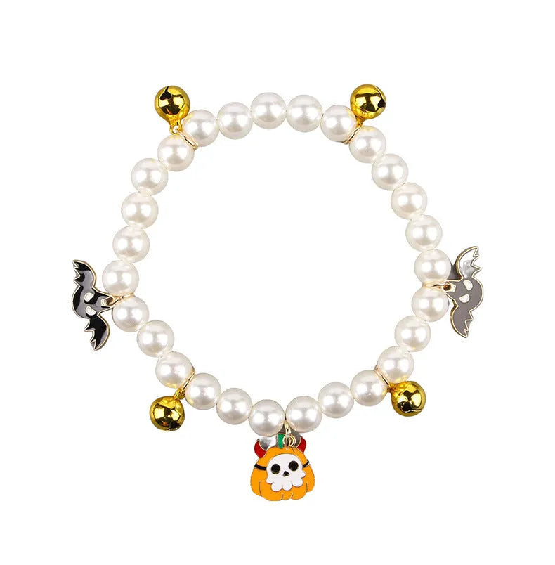 Three pearl necklaces with bells for pets laid out for Halloween costume decoration
