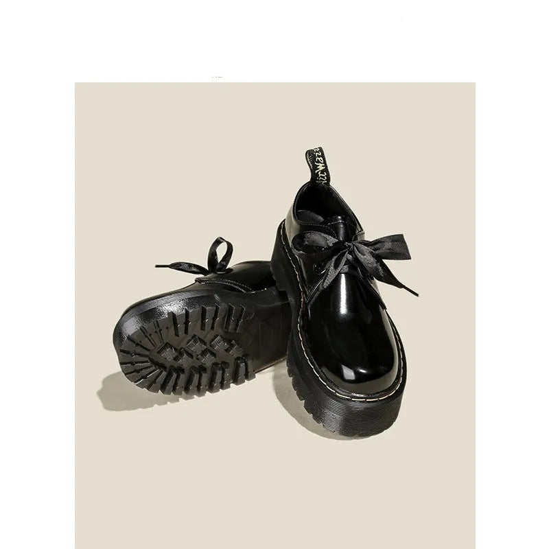 Women's black thick-soled leather shoes with cross strap design and lace-up closure