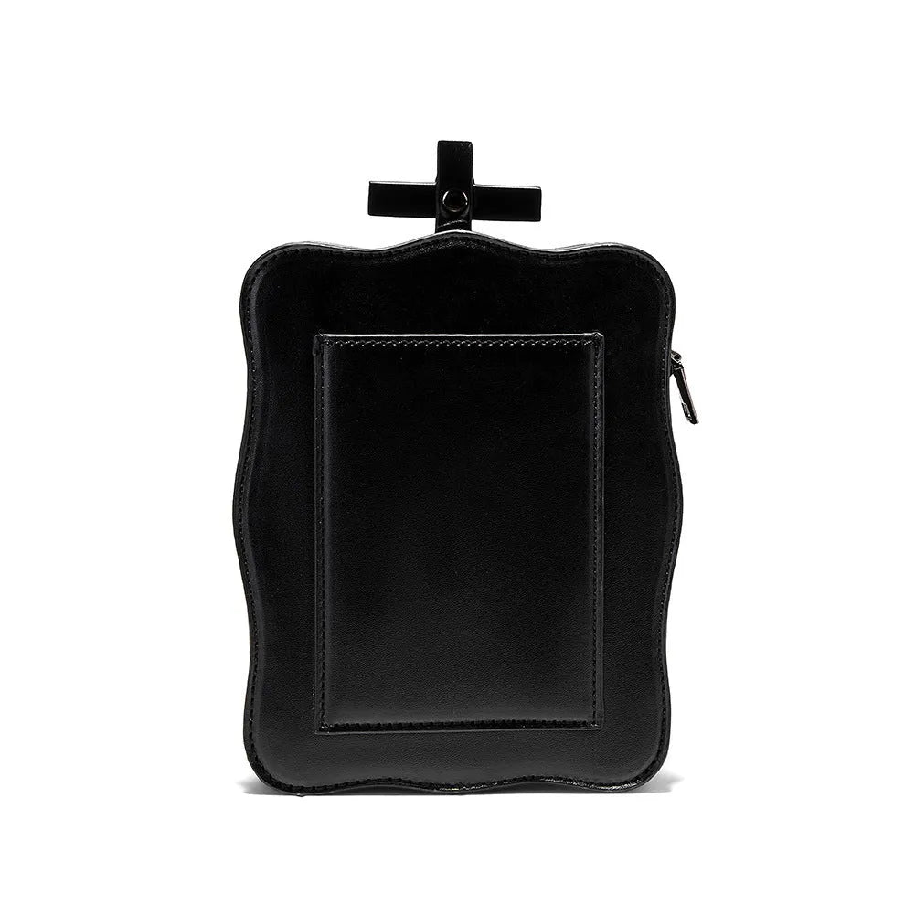 Black mini square crossbody bag with embossed skull design, chain accents, and zipper closure