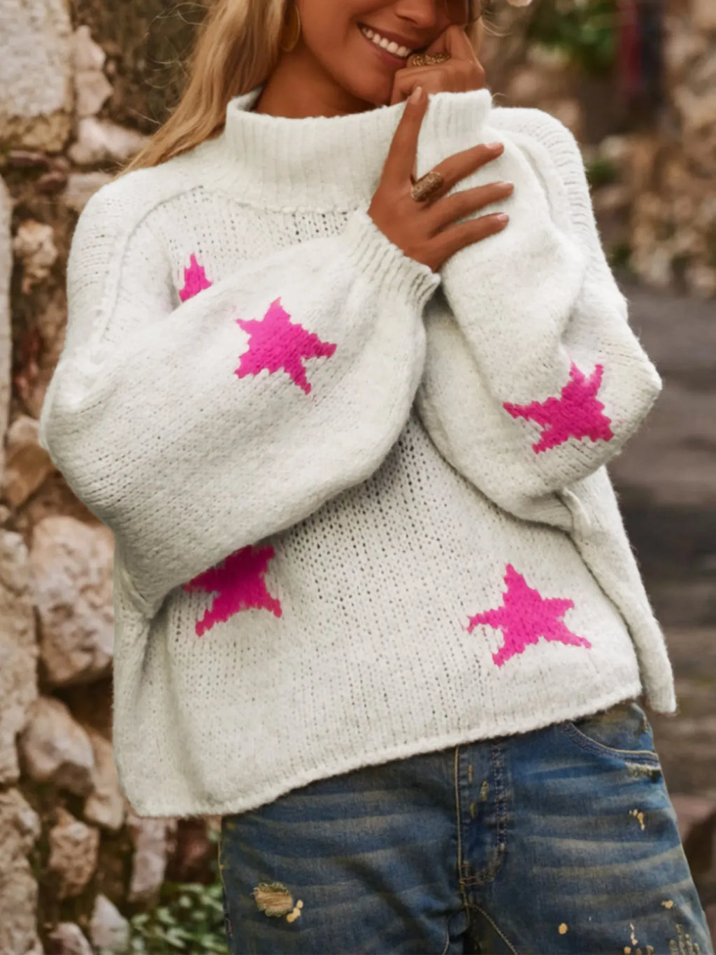 Women's white loose turtleneck pullover sweater with a black five-pointed star pattern on the front.