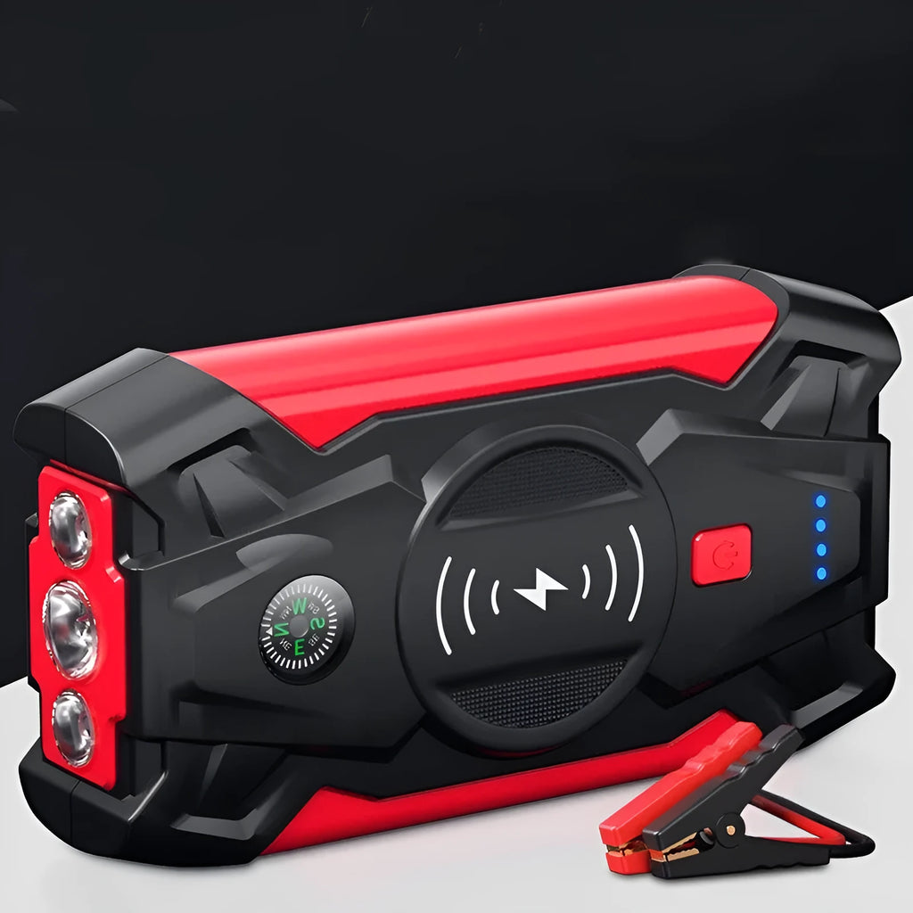 Compact red car battery jump starter unit with cables and clips on a dark background.