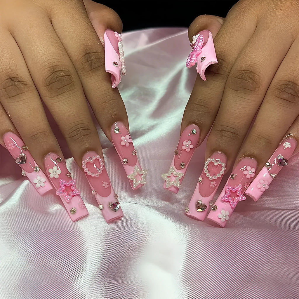 Super long false nails with a red love pattern, spot drill details, and a bow accent on a plastic armour suit.