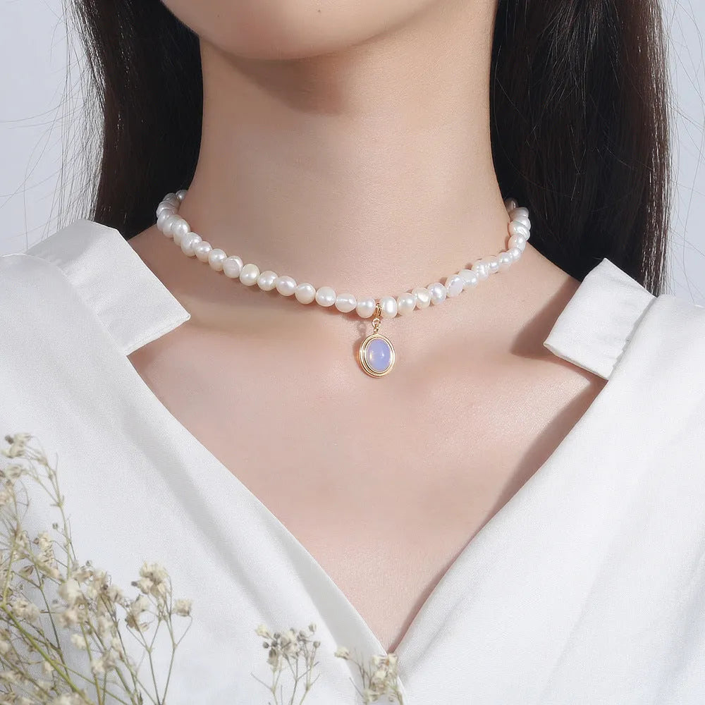 Silver geometric necklace with an irregular pearl pendant on an adjustable chain.