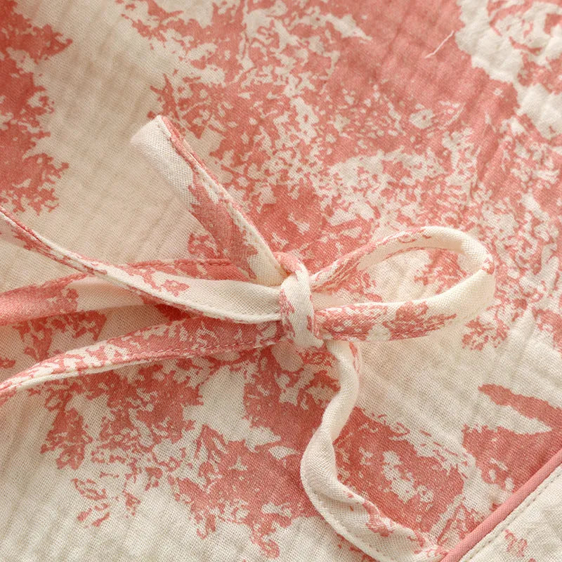 Women's pink cotton gauze lounge suit set with long sleeve top and trousers on a hanger.