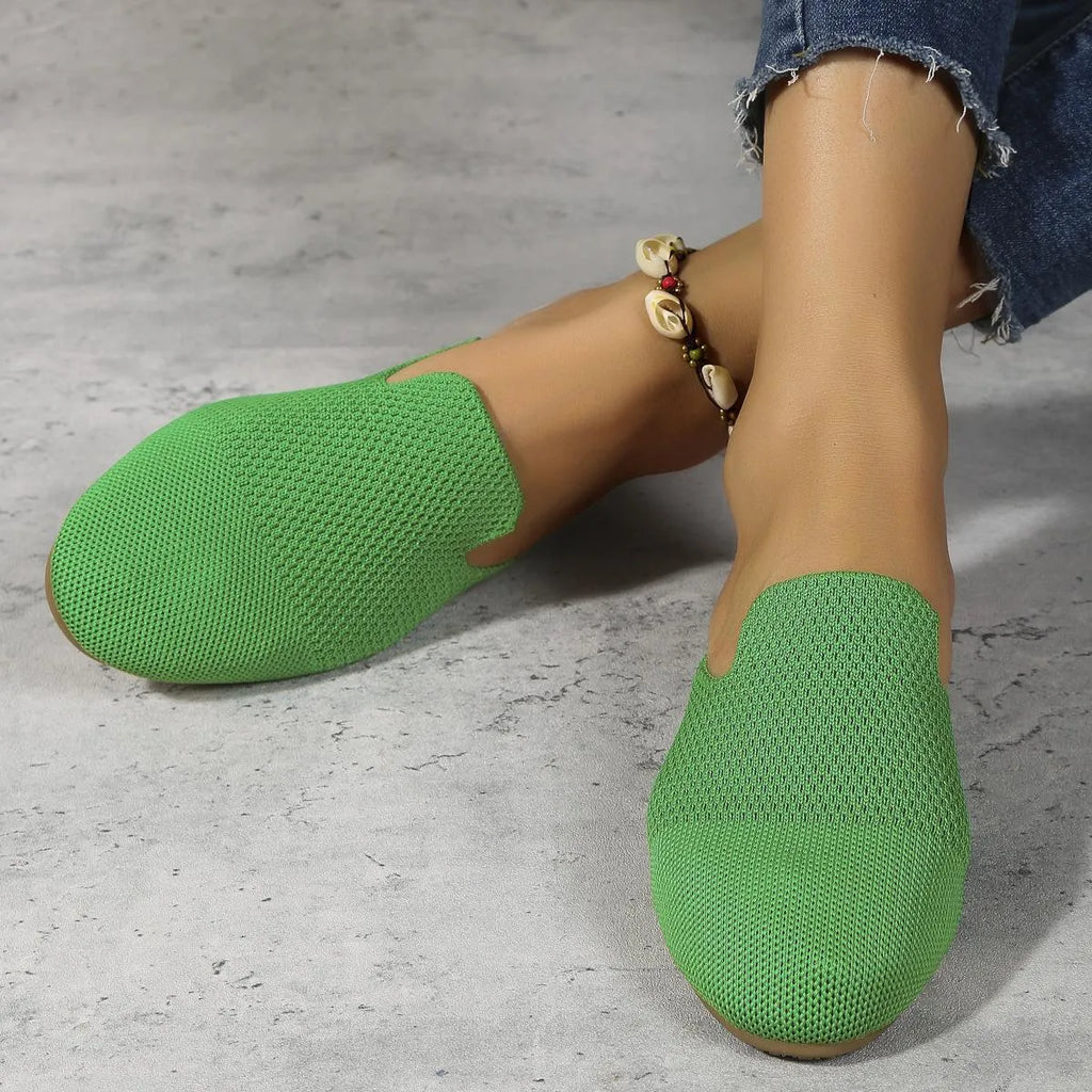 A pair of apricot-coloured mesh slip-on sandals with a round toe and flat rubber sole on a plain background.