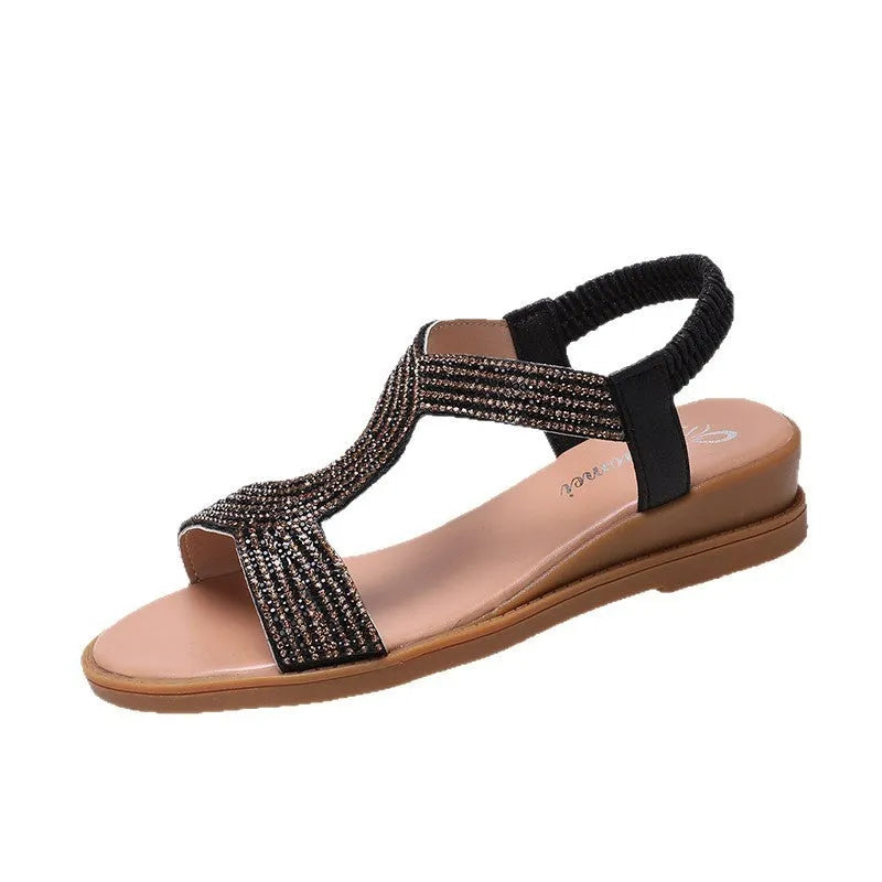 Women's gold patent leather beach sandals with rhinestone decoration on a rounded toe strap.