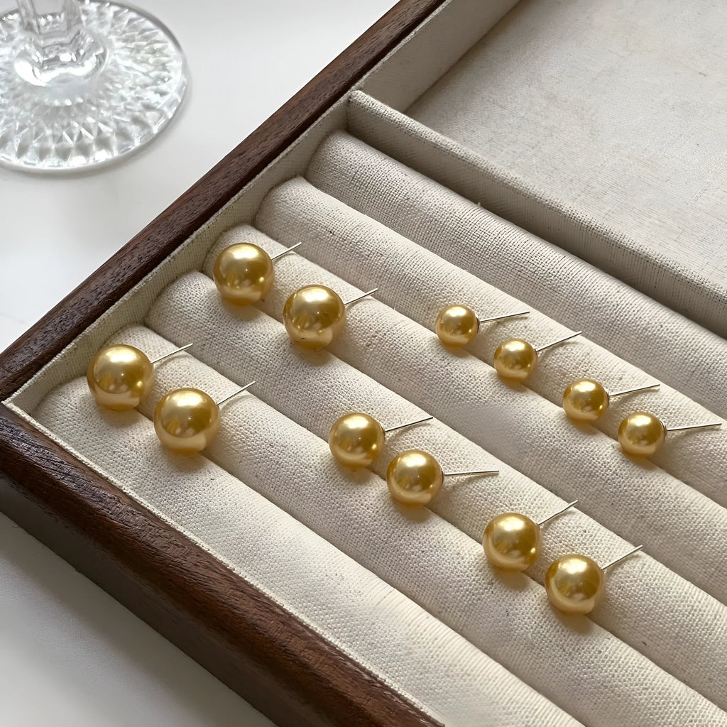 Geometric large pearl stud earrings with eight-point star design in silver setting.