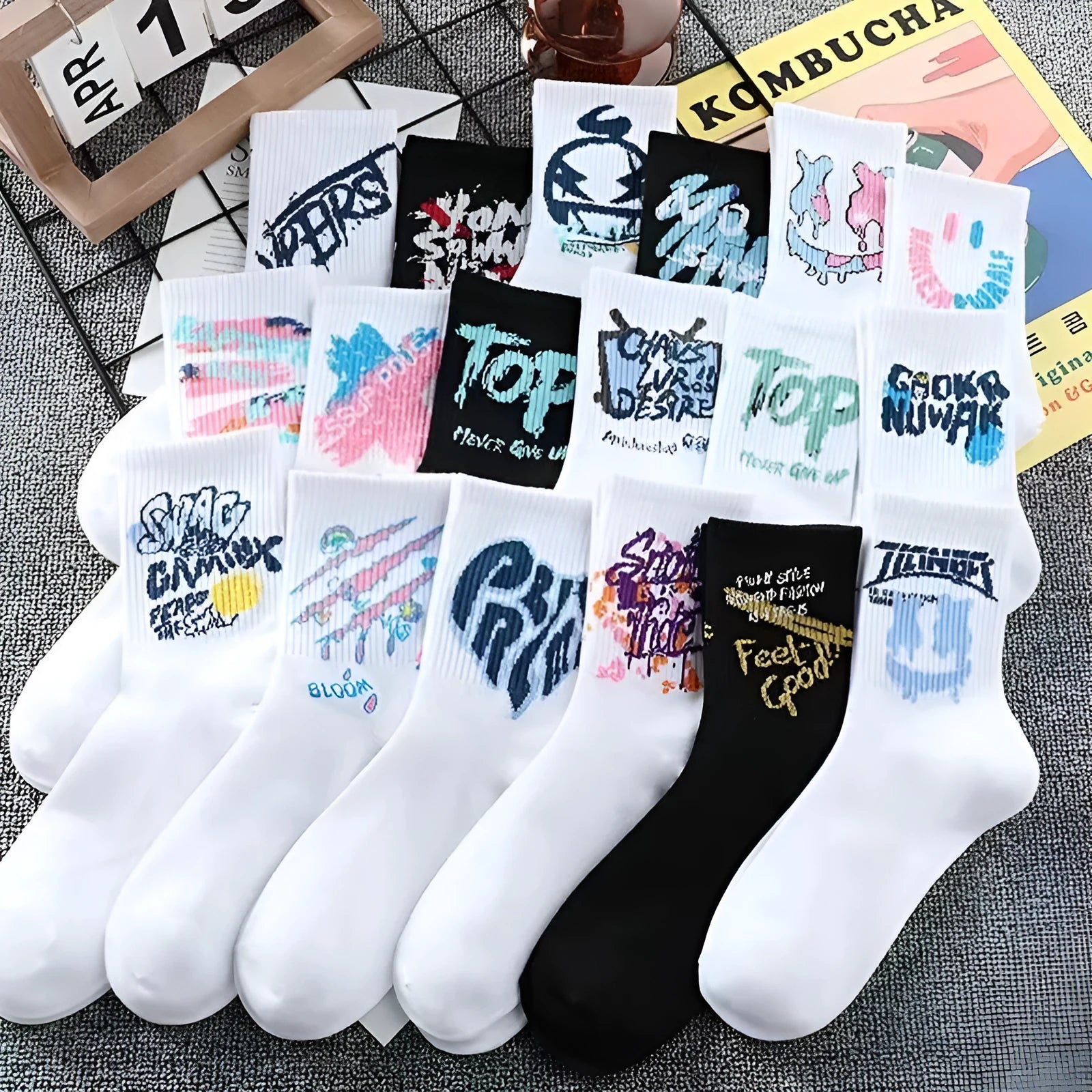White cotton tube socks with graffiti pattern and middle calf length on plain background