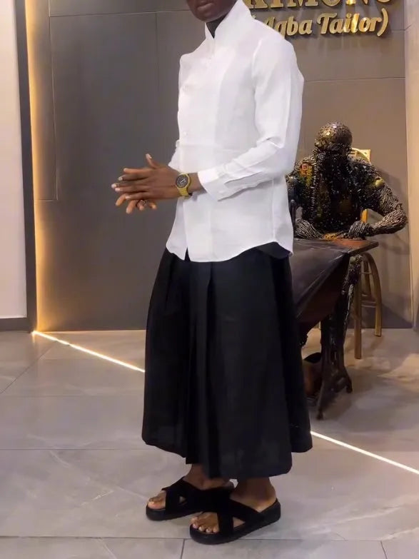 White asymmetric front long sleeve shirt and black pleated pants set on display