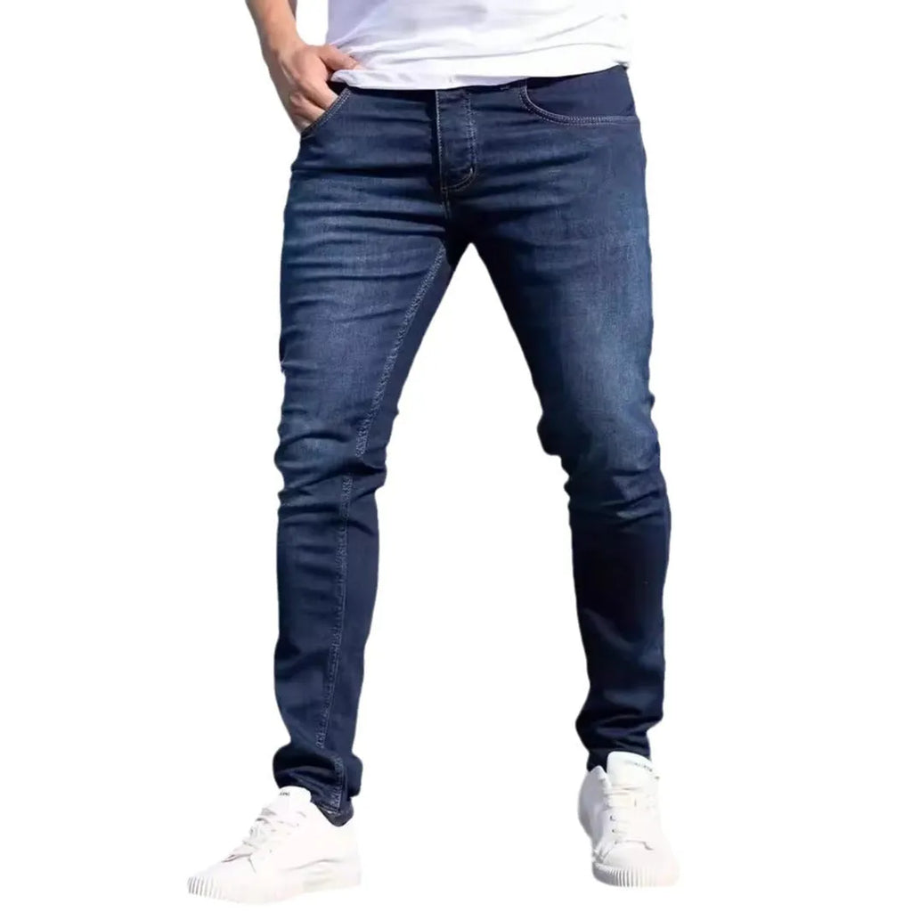 Dark blue men's slim fit skinny jeans with stretch cotton fabric on a mid waist.