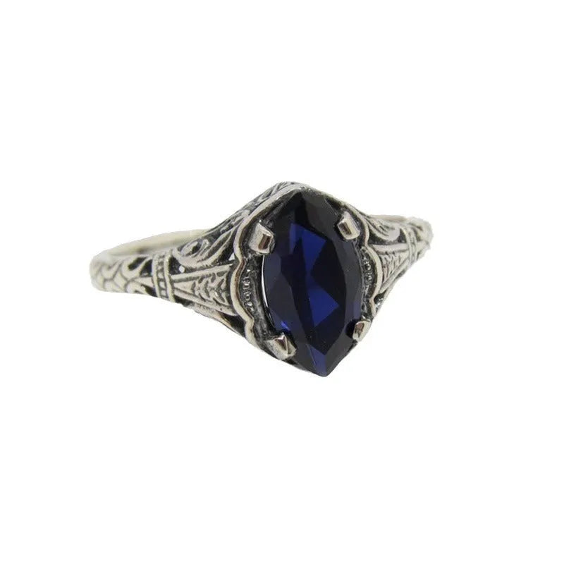 Women's silver alloy ring with geometric hollow design and central zircon stone, on a plain background