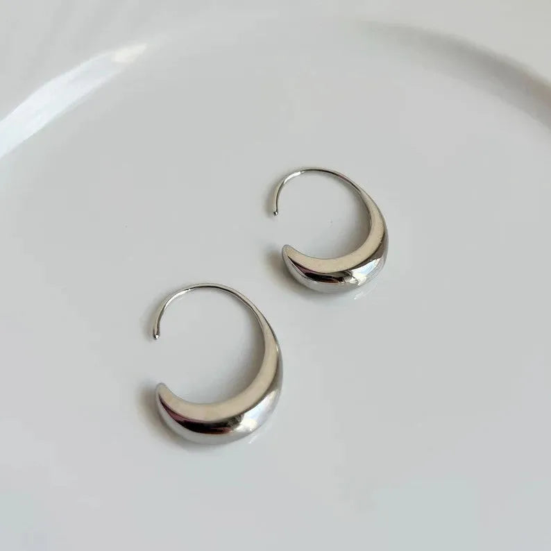 Gold electroplated alloy snake design drop earrings on a neutral background