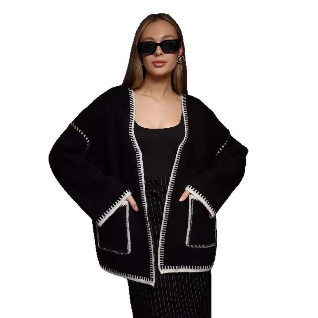 Loose knit camel coloured cardigan sweater with long sleeves on a hanger
