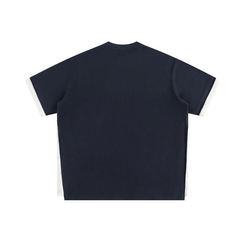 Retro alphabet embroidered loose waffle short-sleeved t-shirt in navy blue on a hanger.