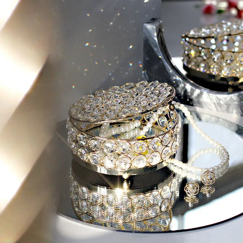 Clear crystal glass jewellery box with a French gold metal frame on a table.
