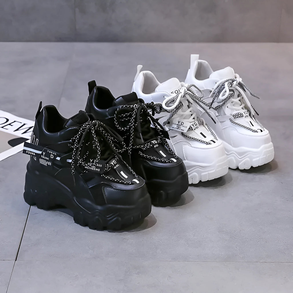 Women's white mesh platform trainers with cross strap and rubber sole showing side profile