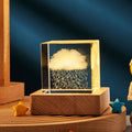 3D transparent crystal cube night lamp with warm light pattern on wooden desktop