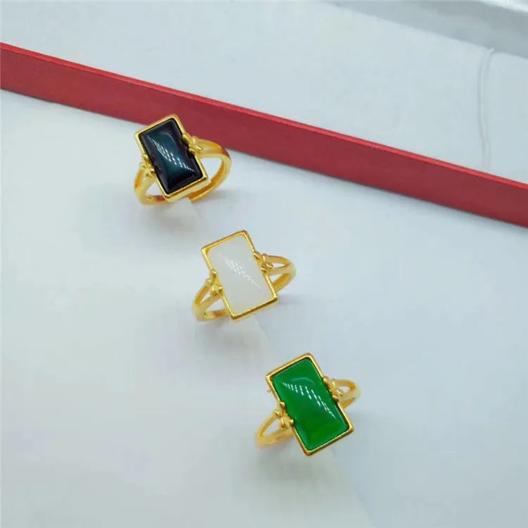 Adjustable brass gold-plated ring with electroplated finish and a coloured gemstone.