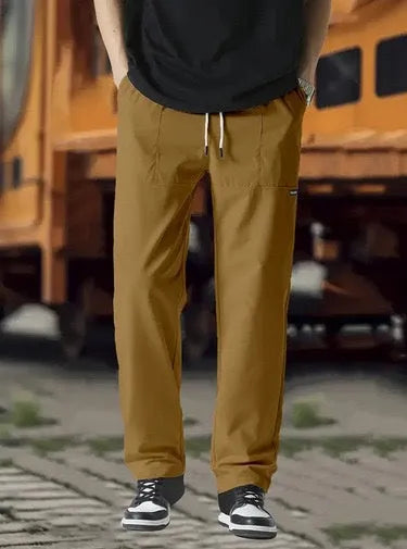 Men's polyester trousers in light grey, shown folded, for casual spring and autumn wear.