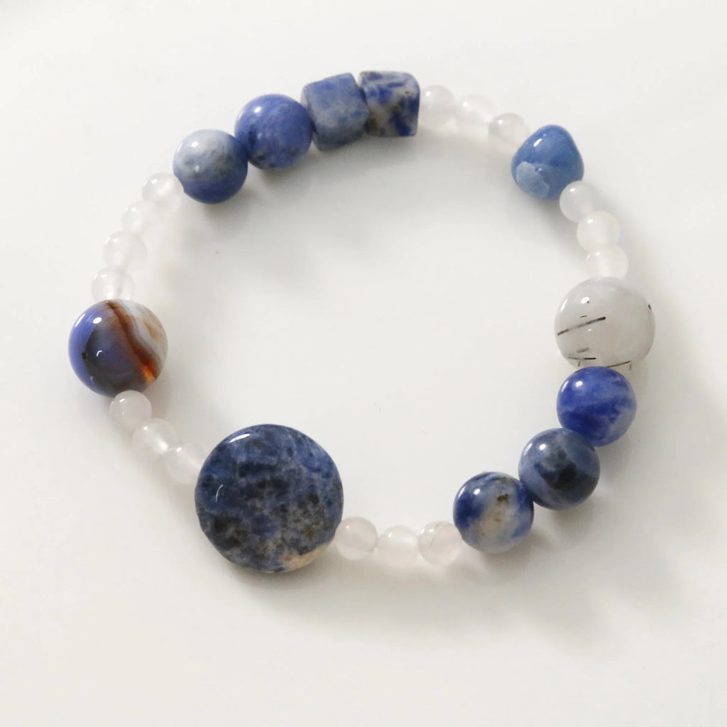 Natural blue point stone and black hair crystal agate hand-woven unisex bracelet with round and oval beads on white background