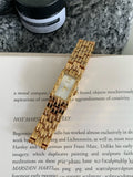 Women's stainless steel bracelet watch with 15mm dial, showing gold strap and white face option.