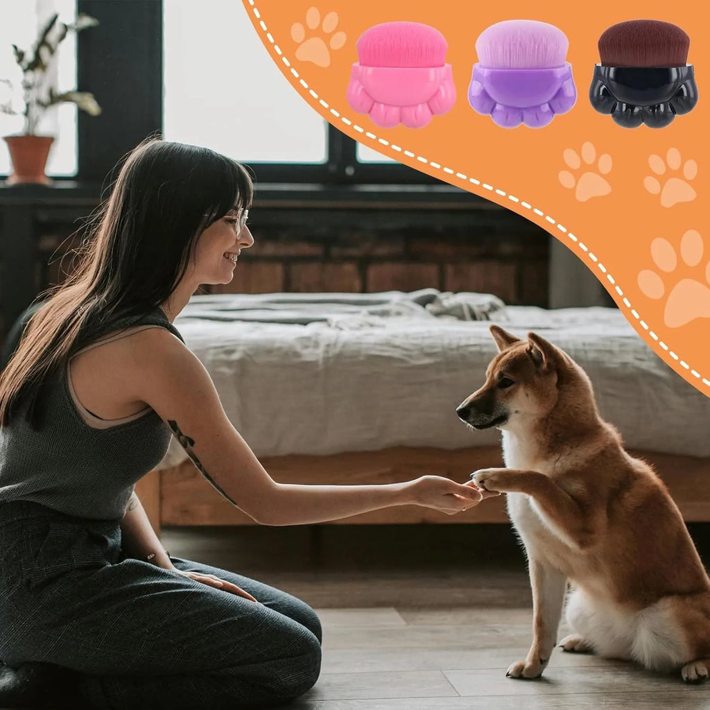 Three dog paw balm brushes with soft fibre heads and paw-shaped plastic handles, each in a small clear storage box