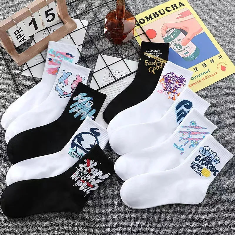 White cotton tube socks with graffiti pattern and middle calf length on plain background
