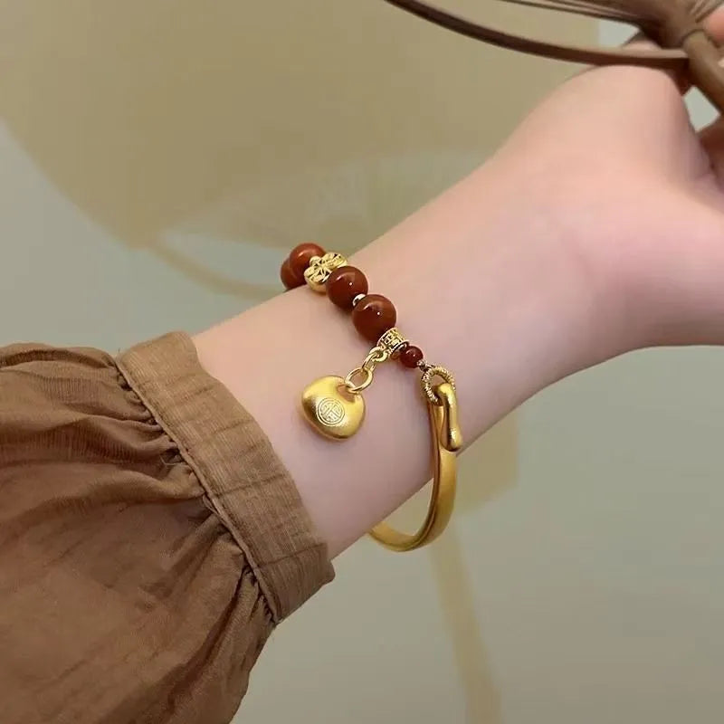Golden South Red Agate Character Ingot Bracelet with lucky bag charm on a white background