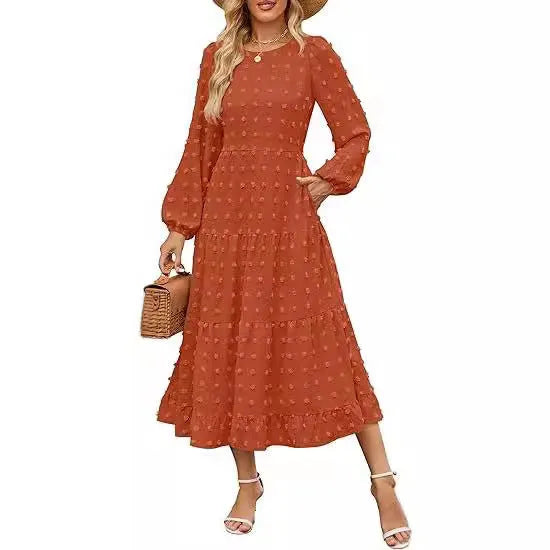 A woman wearing a beige high waist long sleeve dress with ruffle details on a autumn day.