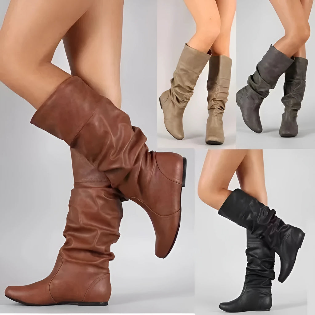 Women's black slip-on flat ankle boots with round toe and high shaft on a neutral background.