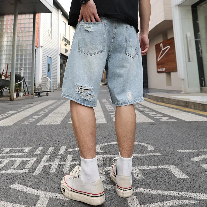 Men's light blue ripped denim shorts with distressed detailing and straight leg cut