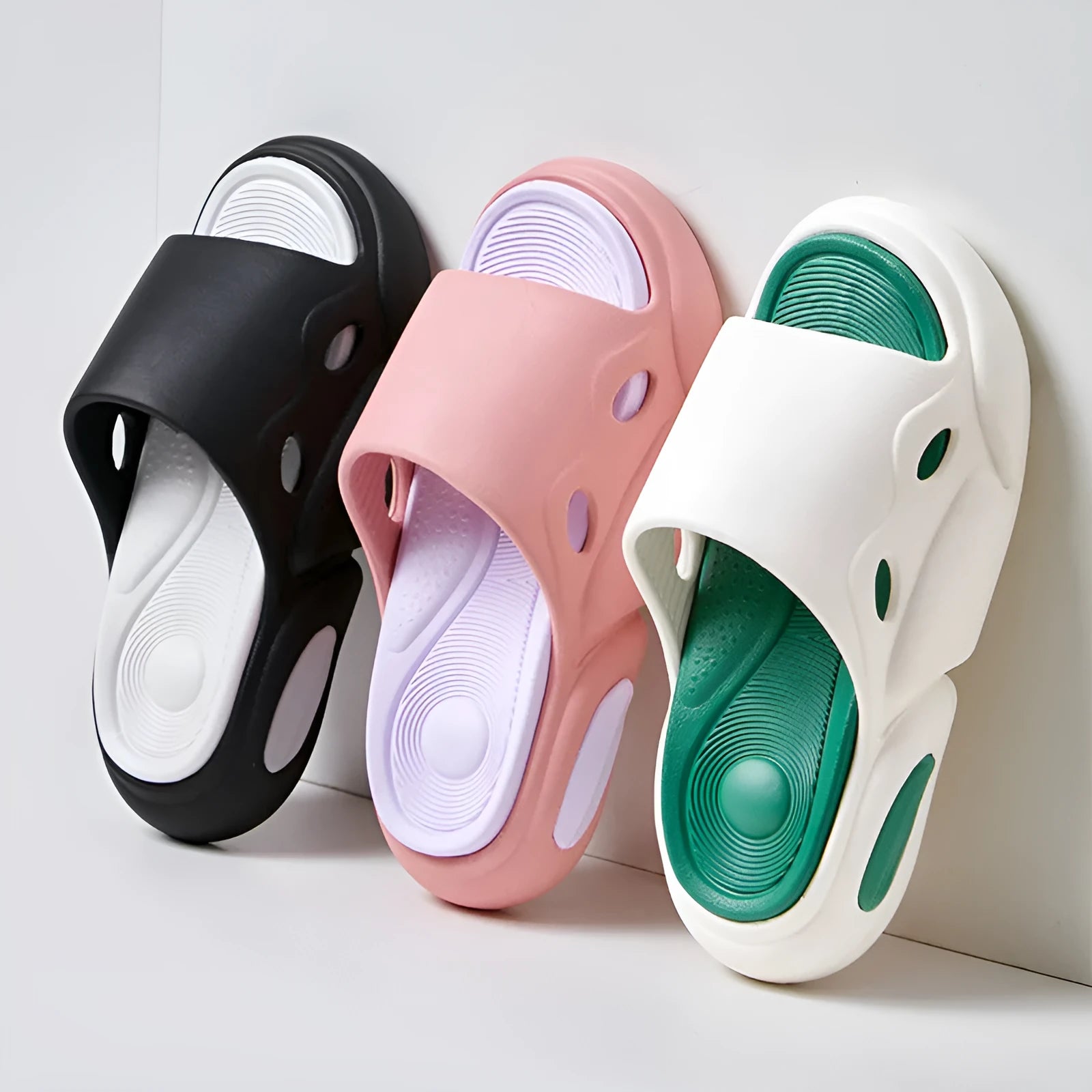 Two-colour couple slippers showing thick EVA sole and round toe, displayed in black and white colourway.