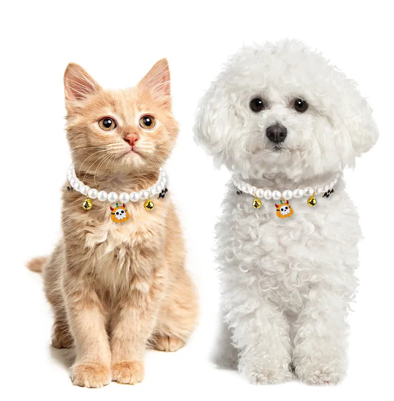 Three pearl necklaces with bells for pets laid out for Halloween costume decoration