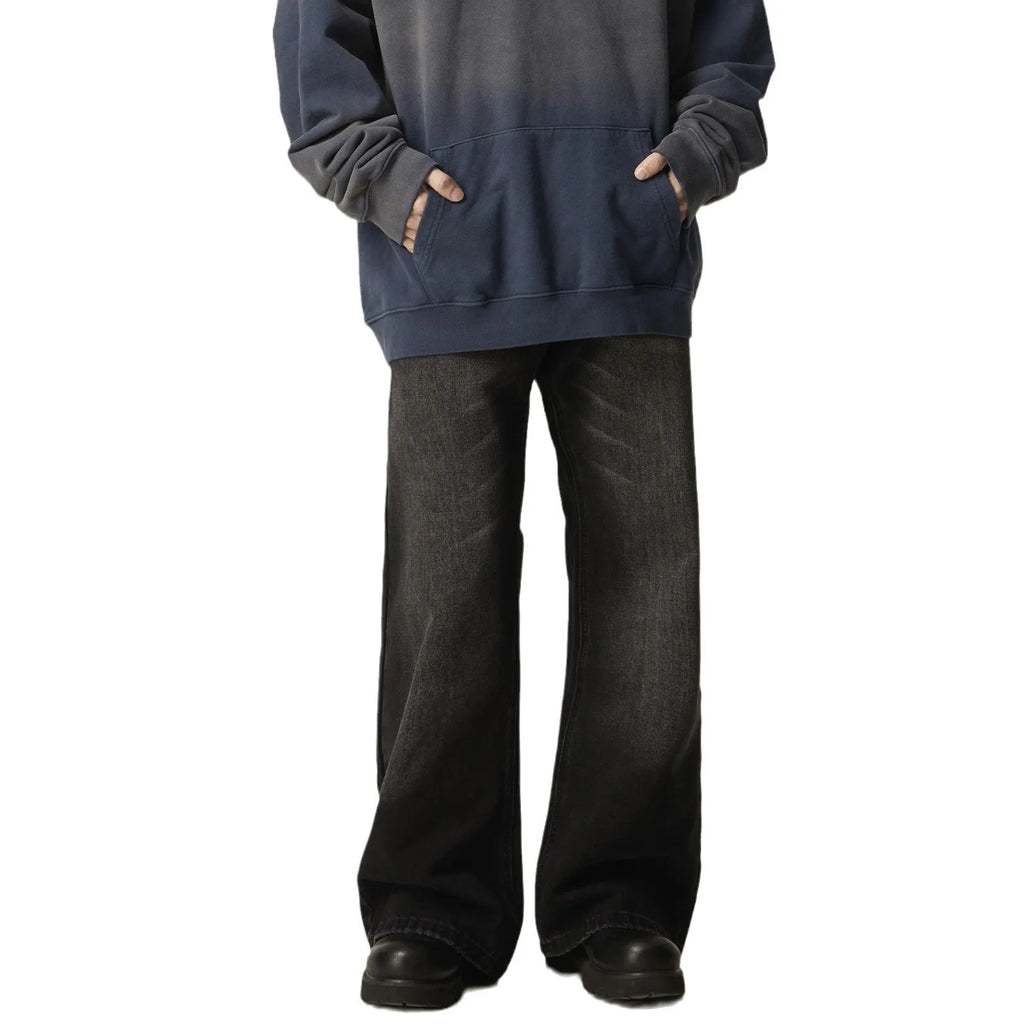 Man's black loose-fit straight-leg jeans with a retro style on a plain background.