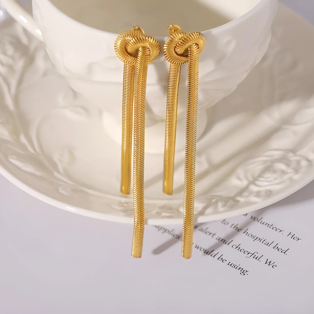 Gold knotted tassel snake chain long necklace with matching earrings on white background