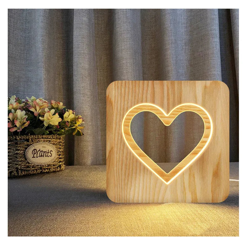 Solid wood hollow night lamp with warm white LED light, USB cable, and button switch on a wooden table