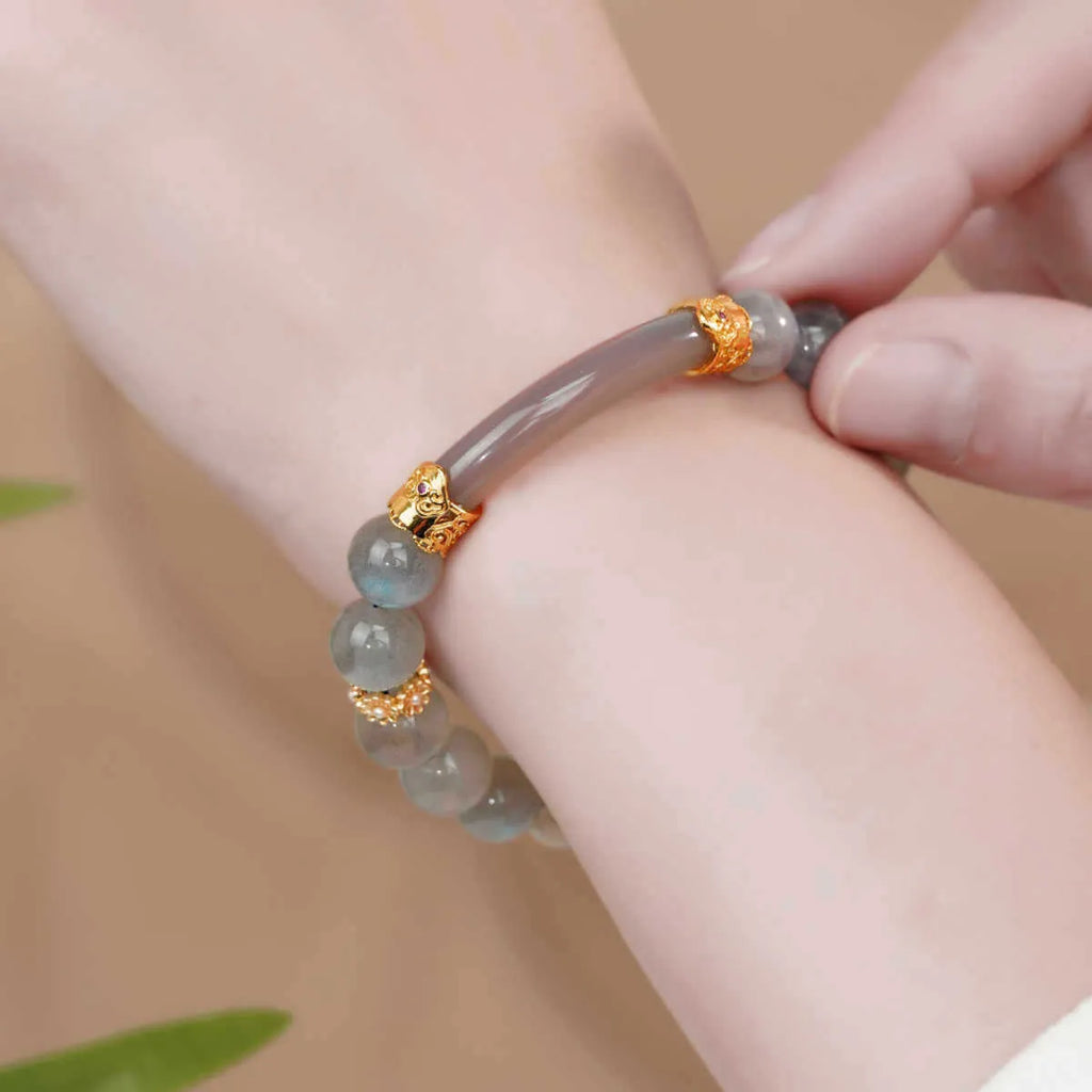 Gray moonstone agate half bracelet with round 8mm beads on a plain background