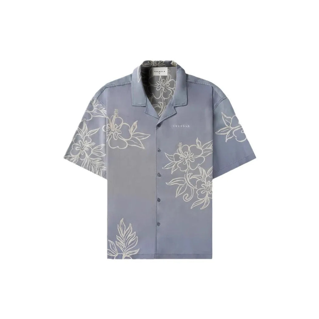 Man wearing a loose grey short-sleeve top with a floral print pattern