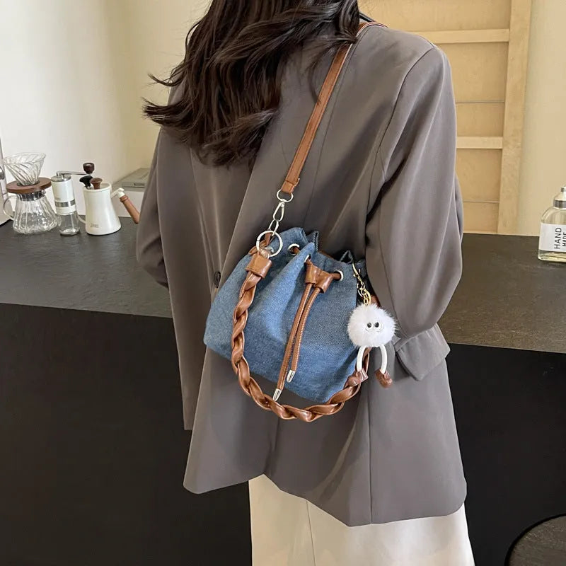 Blue synthetic leather cross body bucket bag with one-shoulder strap and sandwich pocket design