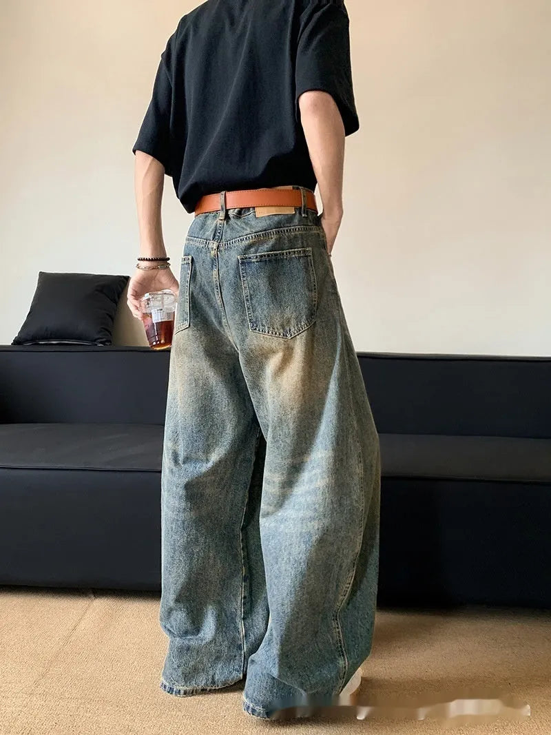 Men's retro blue distressed denim trousers with wide leg cut and vintage wash detailing