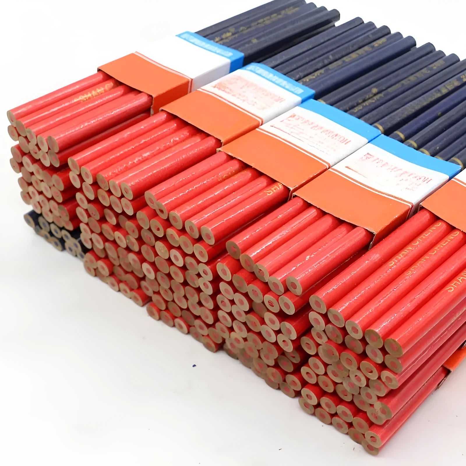 Ten red and blue round wooden carpenter pencils for marking, laid out on a work surface.