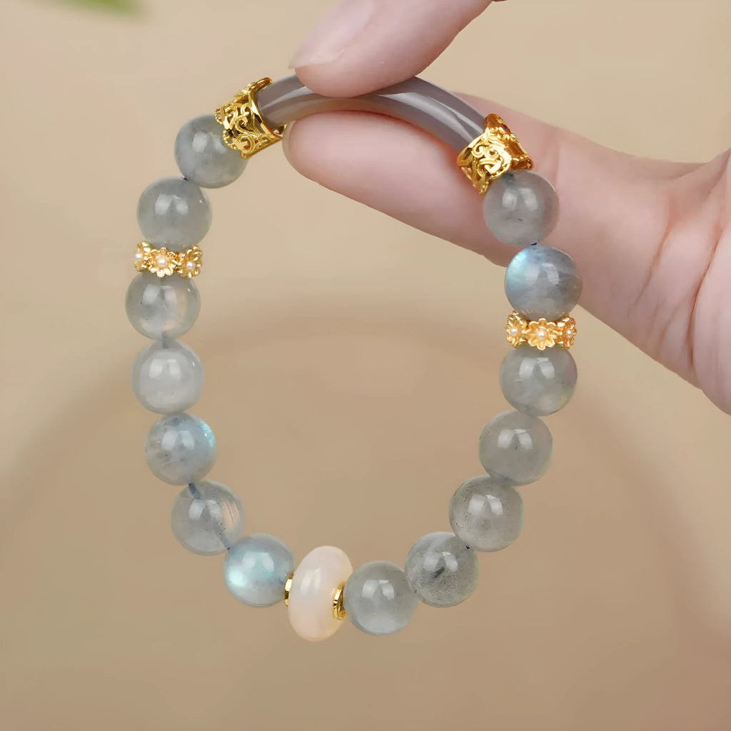 Gray moonstone agate half bracelet with round 8mm beads on a plain background