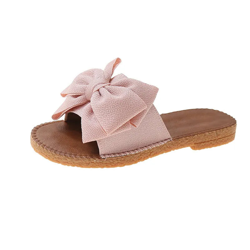 Women's slip-on suede sandals with bow, soft flat heel, beige colour, on casual setting