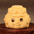 Solid bamboo carving of a cute Golden Toad Princess ornament on a white background.